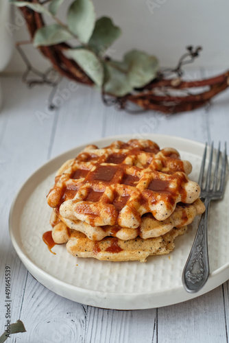 Waffles with caramel sauce. Wooden background. Top view.  © Lyudmila