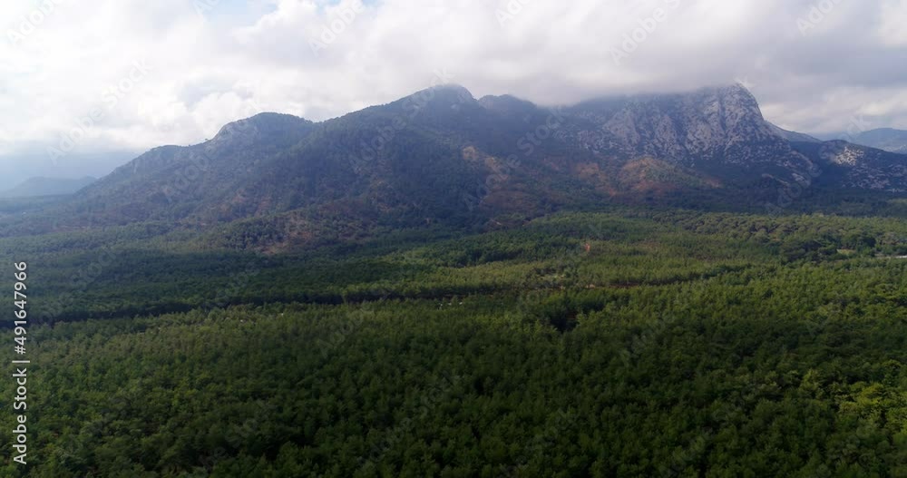 Fly backwards aerial wide angle view of the endless forest in a partly cloudy weather - Mountains of Antalya Fly backwards aerial wide angle view of the endless forest in a partly cloudy weather - Mountains of Antalya