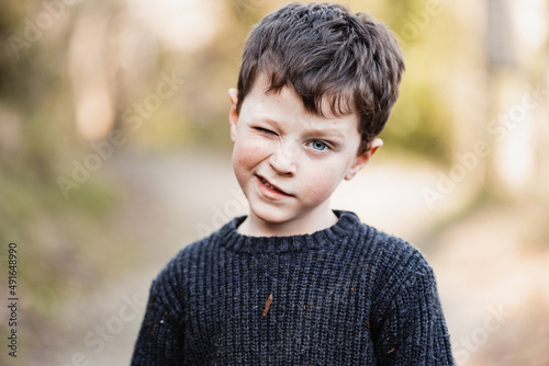 Boy in warm sweater winking at camera photo