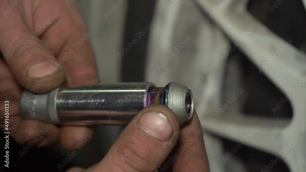 Mechanic is Tightening Locking Wheel Nut of Racing Car. Mechanic or Technician is tightening wheel nut of racing car in car repair shop. Slow motion. Mechanic is Tightening Locking Wheel Nut of Racing Car. Mechanic or Technician is tightening wheel nut of racing car in car repair shop. Slow motion.