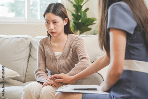 Psychology  depression. Sad  suffering asian young woman  consulting with psychologist  psychiatrist while patient counseling mental problem with doctor at clinic. Encouraging  therapy  health care.