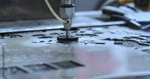 Automated machine for cutting metal with water jet. Water under pressure cuts objects.