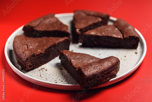 Chocolate Flourless Cake on red background. Soft chocolate gÃ¢teau or Brownie cake. Selective focus