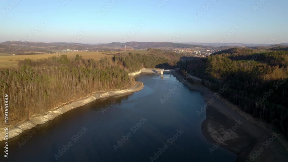 Křetínka Reservoir near Letovice at sunset surrounded by dense forests - drone view Křetínka Reservoir near Letovice at sunset surrounded by dense forests - drone view