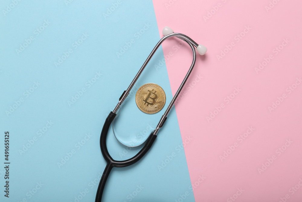 Bitcoin with stethoscope on a blue pink background. Financial analytics, cryptocurrency and trading concept Bitcoin with stethoscope on a blue pink background. Financial analytics, cryptocurrency and trading concept
