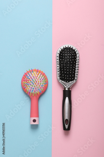 Two combs on a blue-pink pastel background. Top view