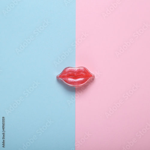 Red lips on a pink blue background. Beauty minimal concept photo