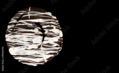 bun covered with chocolate  dark and white  on a black background