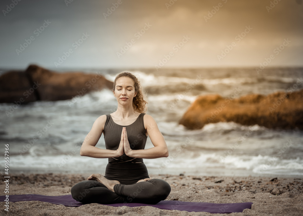 Young yogi woman meditates on the beach. Harmony, balance