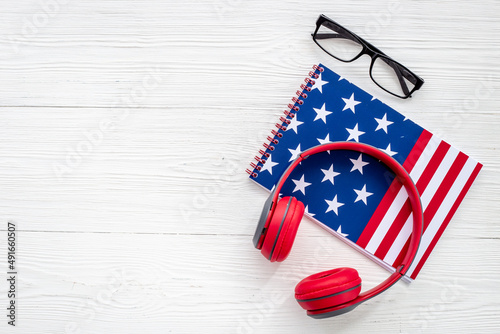 USA flag on notebook with headphones. E-learning language concept