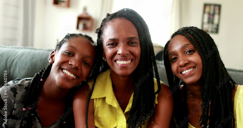 Fototapeta premium Mother and teenager daughters, family love and affection. African ethnicity