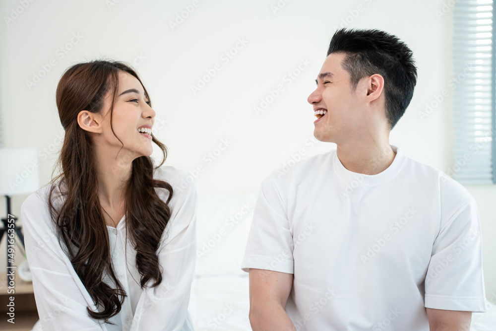 Portrait of Asian new marriage couple sit on bed and look each other. Portrait of Asian new marriage couple sit on bed and look each other.