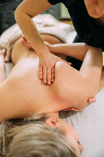 Tiefe Rücken Massage einer Frau mit Schmerzen im oberen Rückenbereich