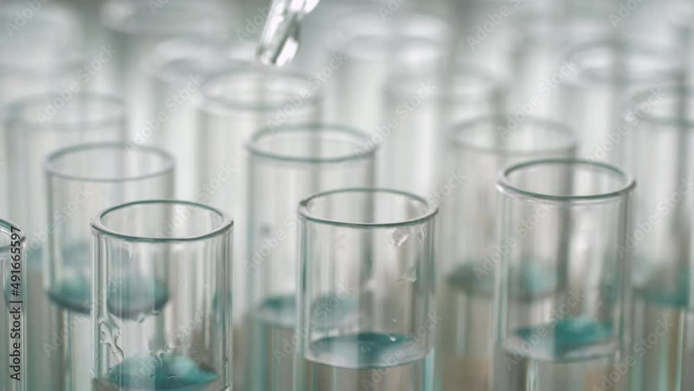Closeup shot of scientist dripping liquid into test tube.
Closeup shot of scientist dripping liquid into test tube.