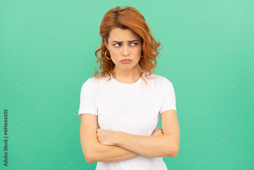 portrait of redhead lady on blue background. express negative emotions portrait of redhead lady on blue background. express negative emotions