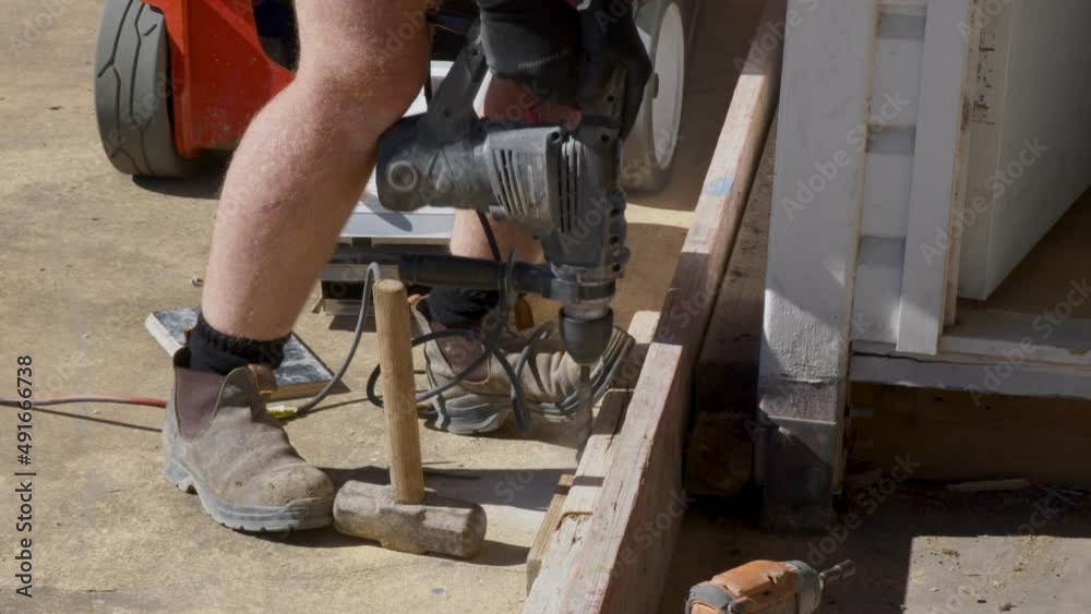 Man with a hammer drill, drilling into concrete. Man with a hammer drill, drilling into concrete.