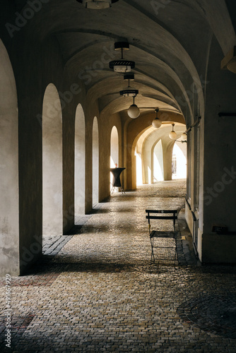Photograph showing the sharp side sun lighting up a corridor near an old house in Prague