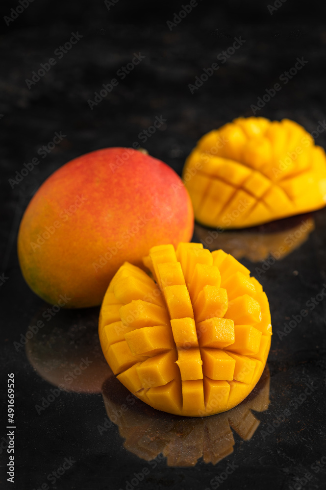 Macro shot of the fresh mango tropical fruit cut in cubes on the dark background Macro shot of the fresh mango tropical fruit cut in cubes on the dark background