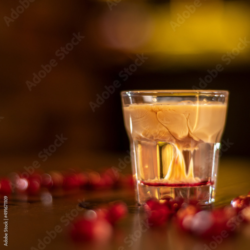 baileys shot with grenadine seeds on wooden table cube