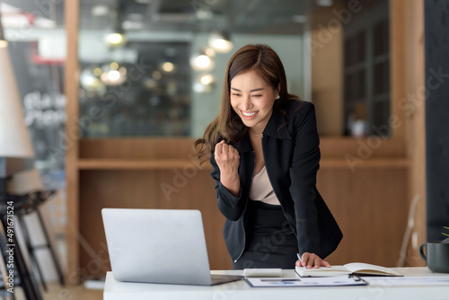 Pretty Asian businesswoman sitting on a laptop And the work came out successfully and the goal was achieved, happy and satisfied with her Fototapeta
