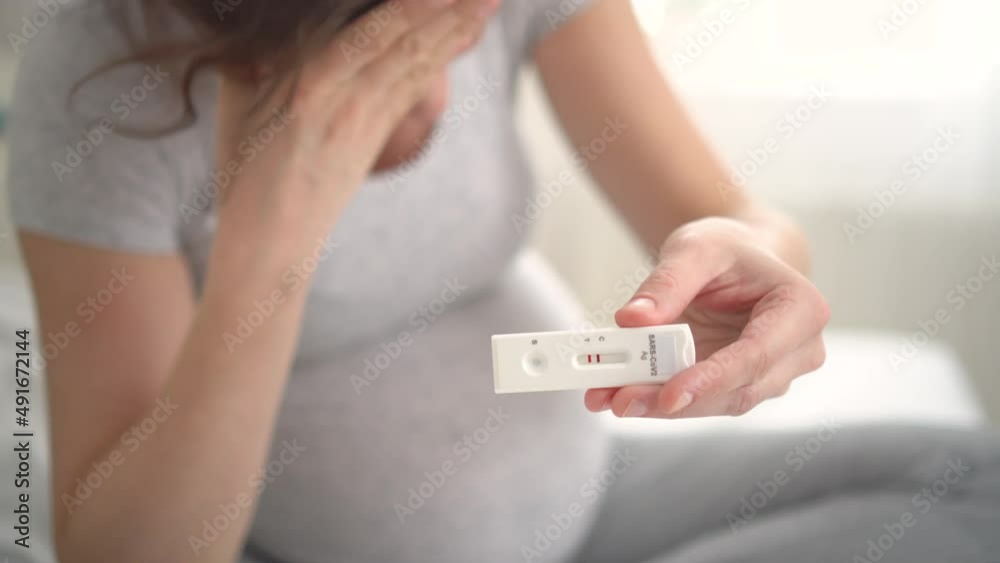 Pregnant woman making test. Close up of fingers holding express antigen covid corona test, positive result sarscov2. Diseases and colds during pregnancy. The concept of health, medicine, gynecology.