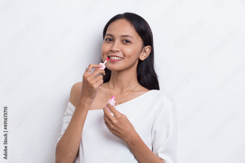 beautiful young asian woman using lipstick isolated on white background
beautiful young asian woman using lipstick isolated on white background