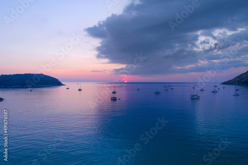 Colorful sunset above the sea surface with sail boats Aerial view sea in Phuket sea Reflected sun amazing light on a water surface Sunset over ocean Seascape Summer and travel vacation concept