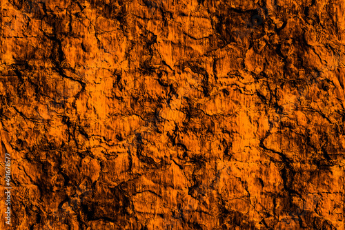 Dark rustic grunge textured surface of orange painted old concrete wall