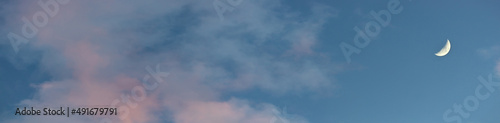 Panoramic colorful dark blue sky replacement image with pink orange wispy clouds and moon