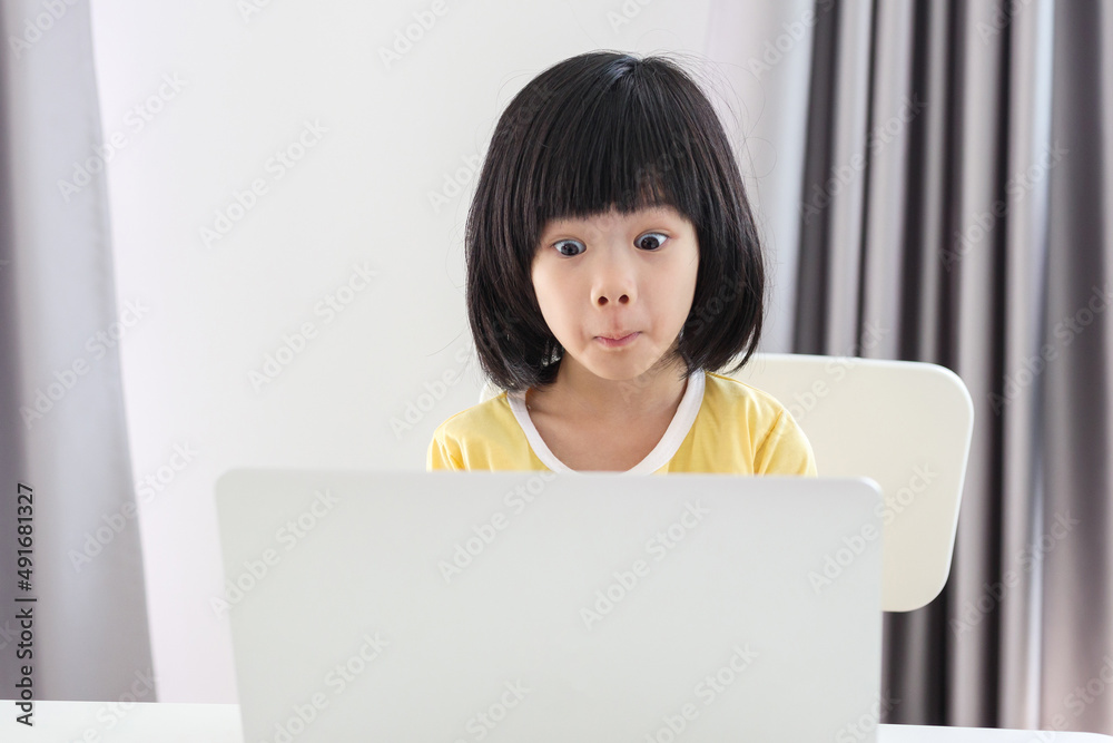 little asian girl student study online using laptop computer at home