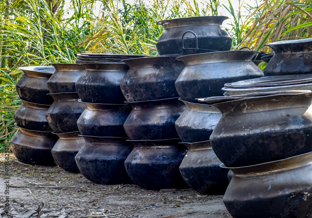 Old used dirty big sized cooking pots stacked on the ground Old used dirty big sized cooking pots stacked on the ground