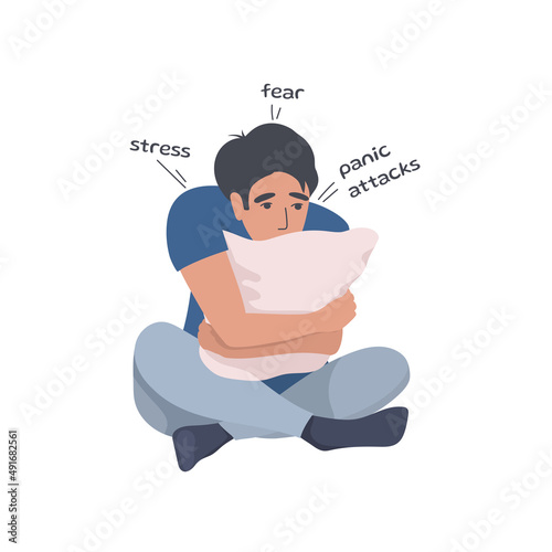 The man hugs the pillow in panic. Panic attacks, fear of the outside world, war and its consequences