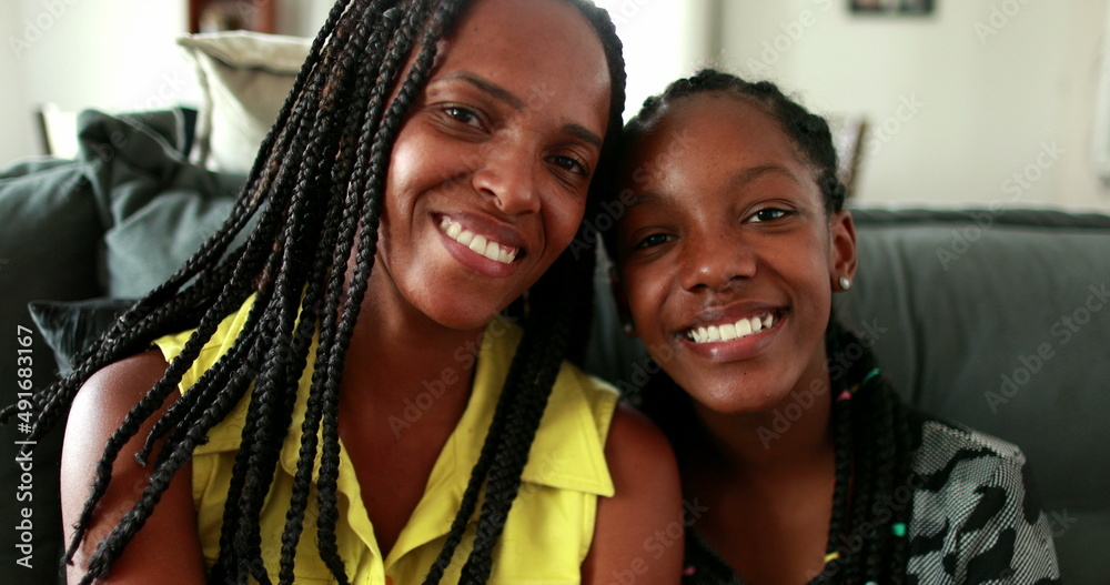 Beautiful black African mother and teen daughter smiling Stock Photo