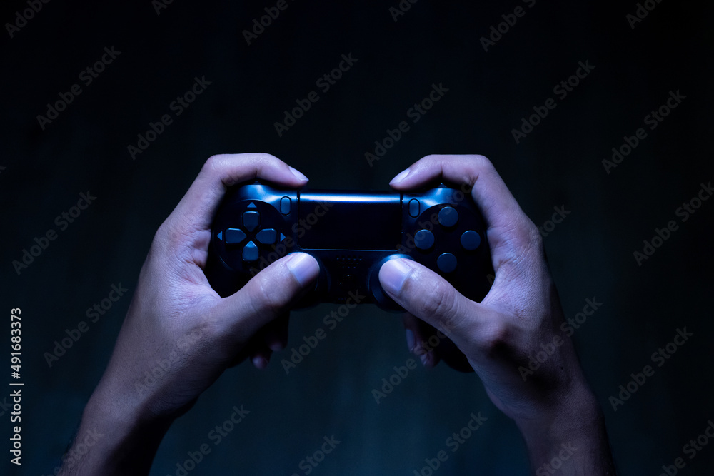 Fototapeta premium close up hand of young man playing video game holding controller