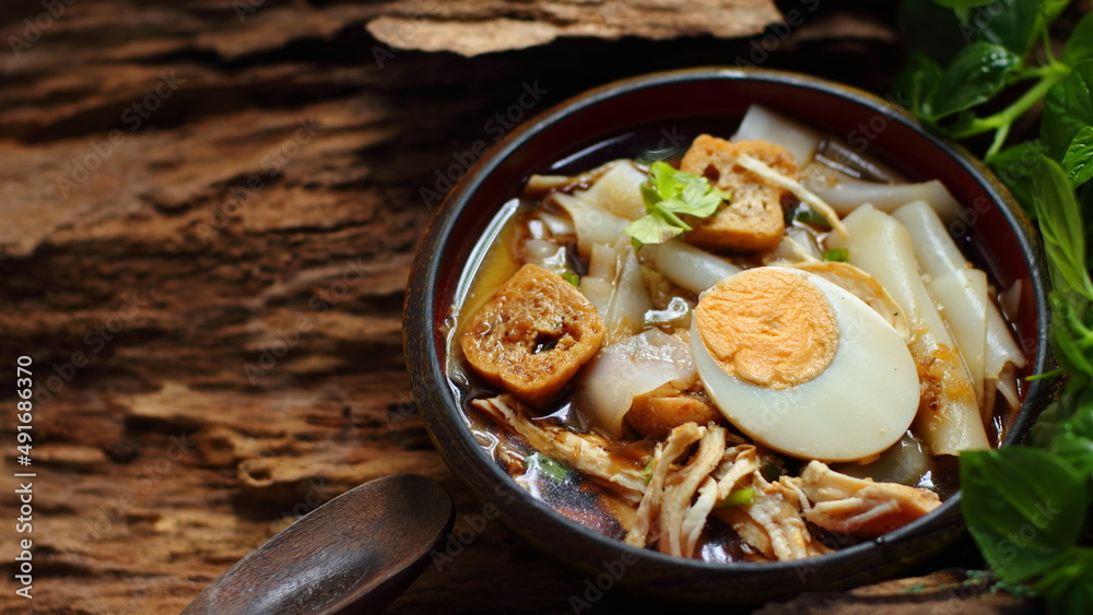 Chinese roll noodle soup with chicken on wooden background Chinese roll noodle soup with chicken on wooden background