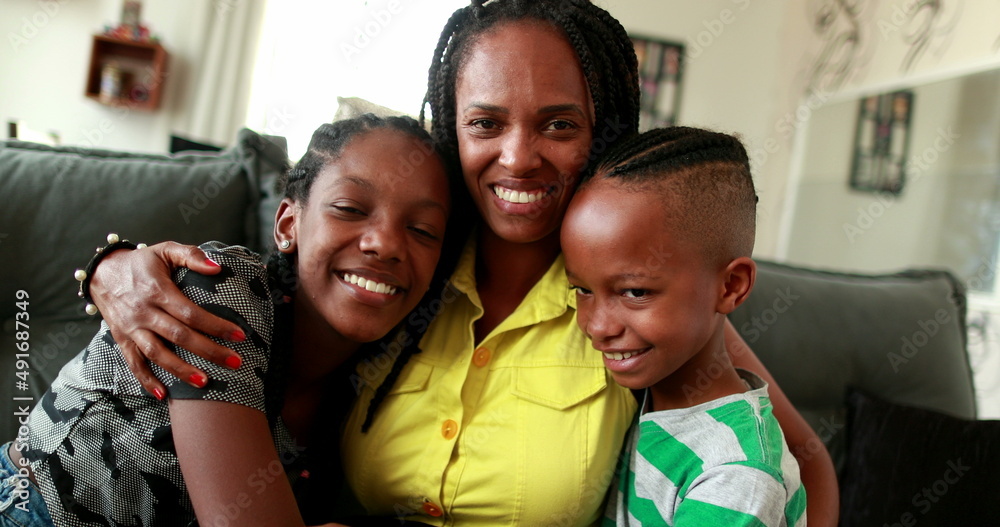 Obraz premium African mother embracing teen daughter and little boy son. African black ethnicity, love and affection