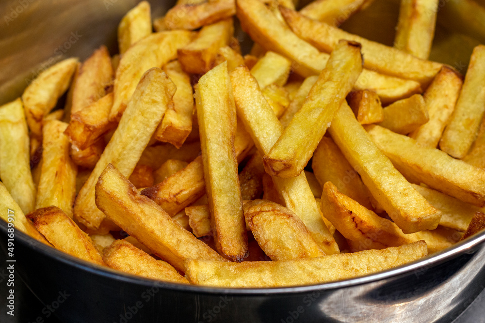 French fries in metal bowl close up image. French fries in metal bowl close up image.