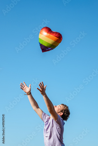 Transgender releasing balloon with LGBT flag in air photo