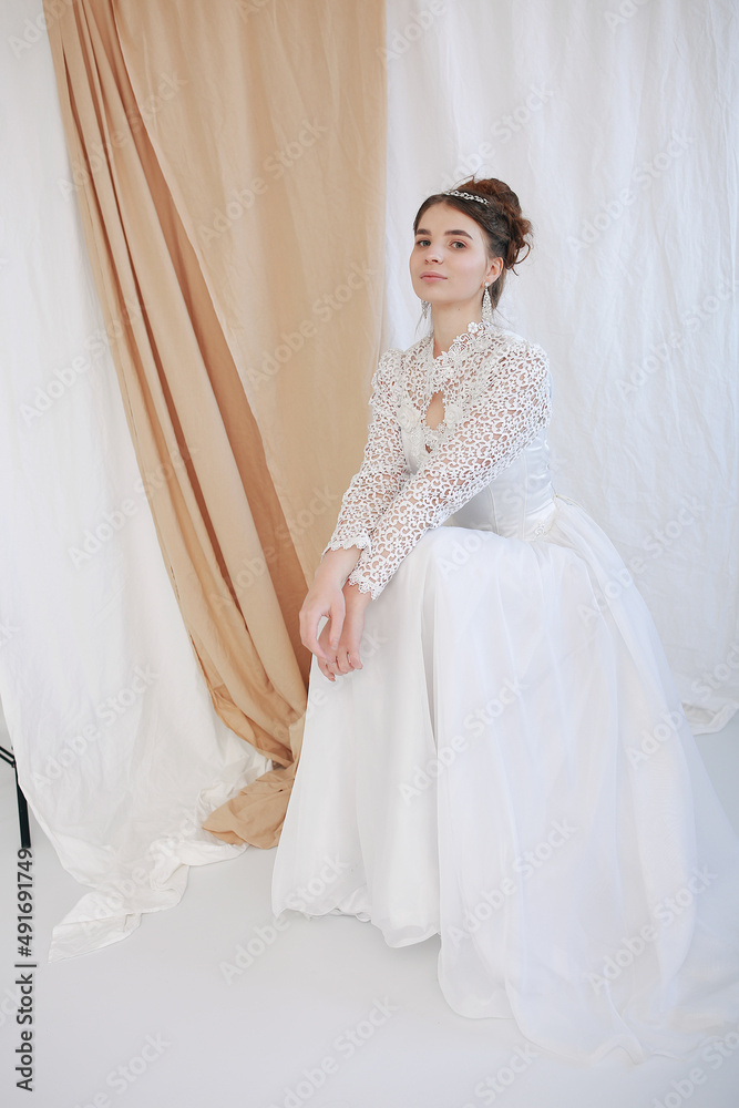 girl in a white wedding retro dress. wedding dress and hairstyle in the style of the 90's. Studio photo shoot in my mother's wedding dress. Bride photo shoot in the studio girl in a white wedding retro dress. wedding dress and hairstyle in the style of the 90's. Studio photo shoot in my mother's wedding dress. Bride photo shoot in the studio