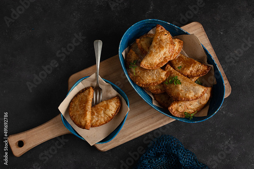 Delicious plate of dumplings and empanadas on a black table photo