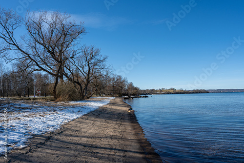 A winter beach covered with snow and a blue sky in the background © Dan