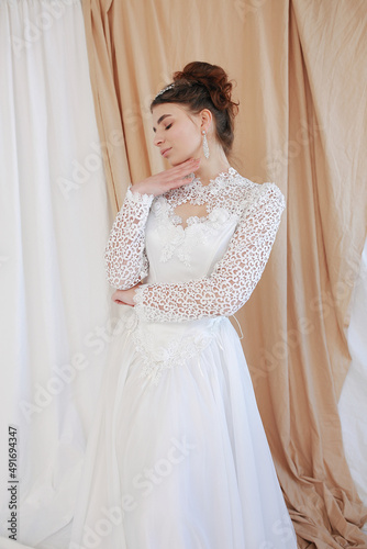 girl in a white wedding retro dress. wedding dress and hairstyle in the style of the 90's. Studio photo shoot in my mother's wedding dress. Bride photo shoot in the studio © Anhelina Tyshkovets