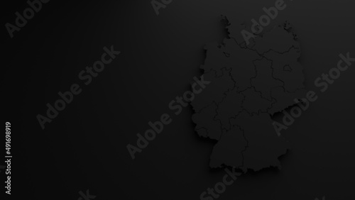 3D rendering of a map of Germany positioned in the right half of the image with federal states in black, in front of a black background, brightened by a light source positioned above it in frontal vie