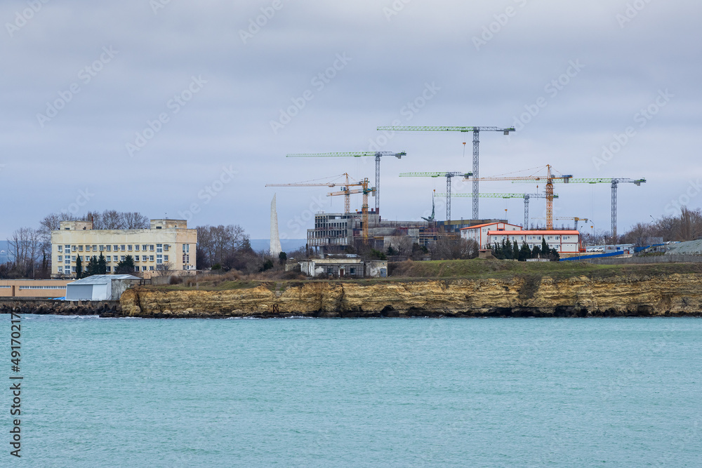 Construction on the sea coast. Lots of construction cranes. Improvement and development in the Crimea. City of Sevastopol.