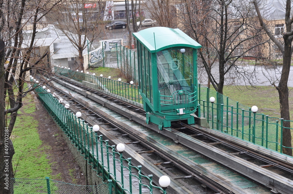 Naklejka premium The green funicular trailer moves along the rails on the slope in Kyiv