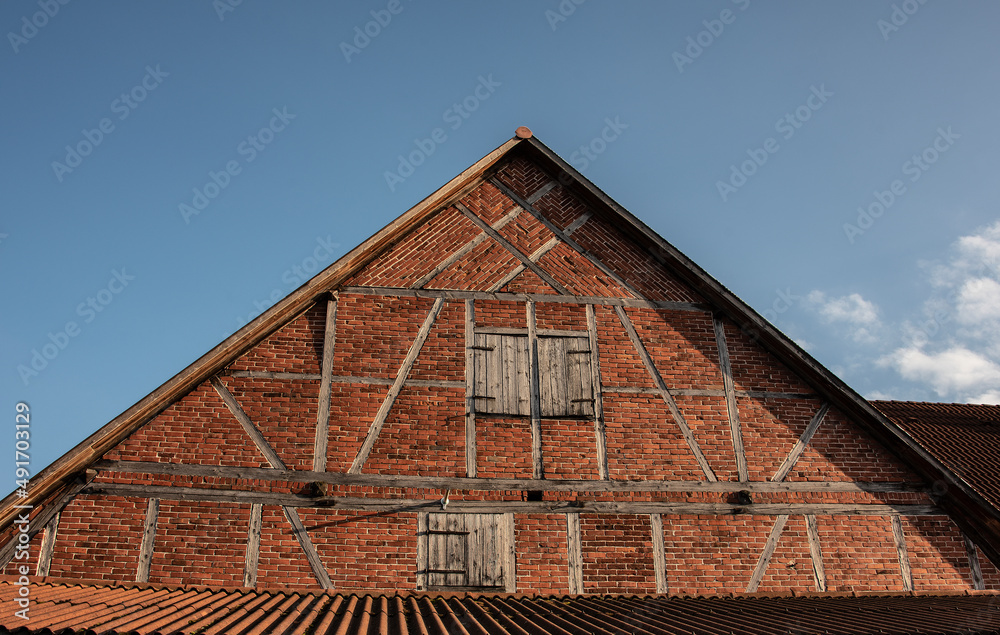 the gable of a half-timbered barn with brick facade