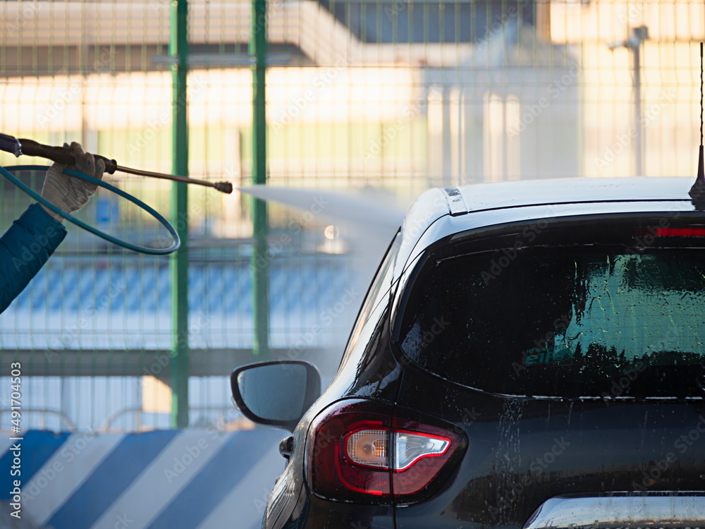 a man is washing a car at the self car wash station