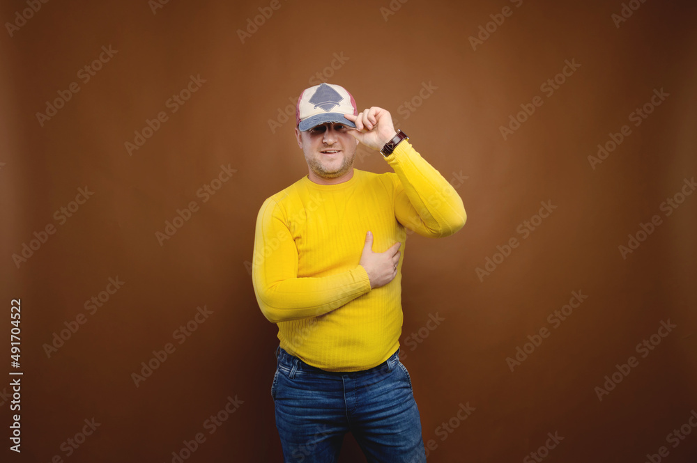 Studio portrait of a plump middle-aged overweight man in bright clothes on a brown background. Nice friendly fat man Studio portrait of a plump middle-aged overweight man in bright clothes on a brown background. Nice friendly fat man