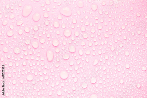 Cosmetic moisturizing liquid drops on pink pastel background. Toner or lotion. Hyaluronic serum