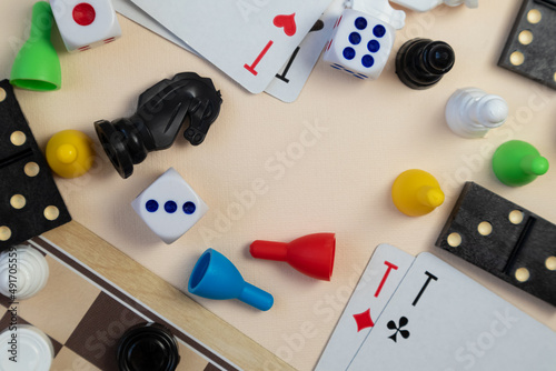 Various board games chess board, playing cards, dominoes on a light background. Space for text.